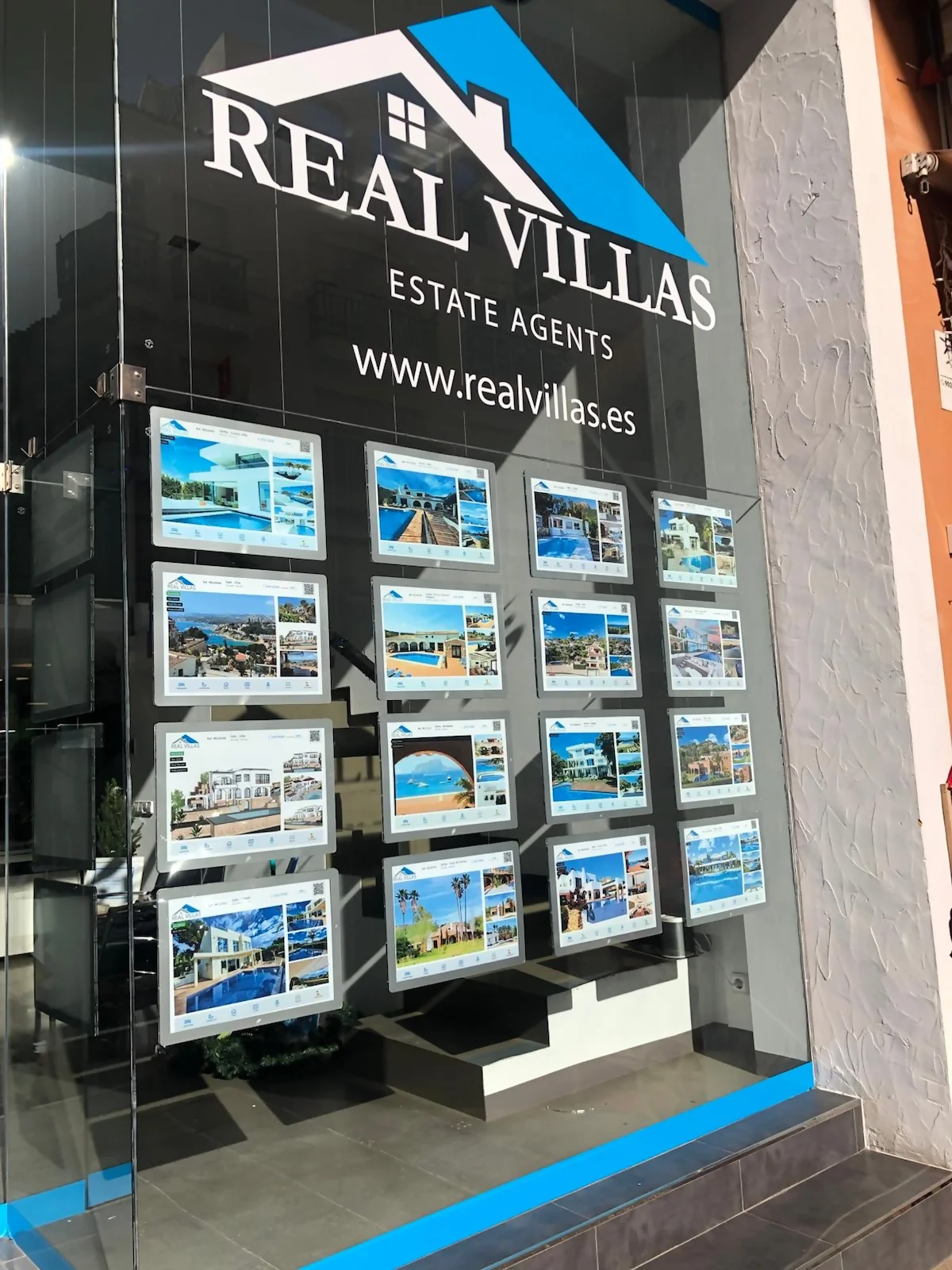 Escaparate inmobiliaria Real Villas con carpetas LED y tensores