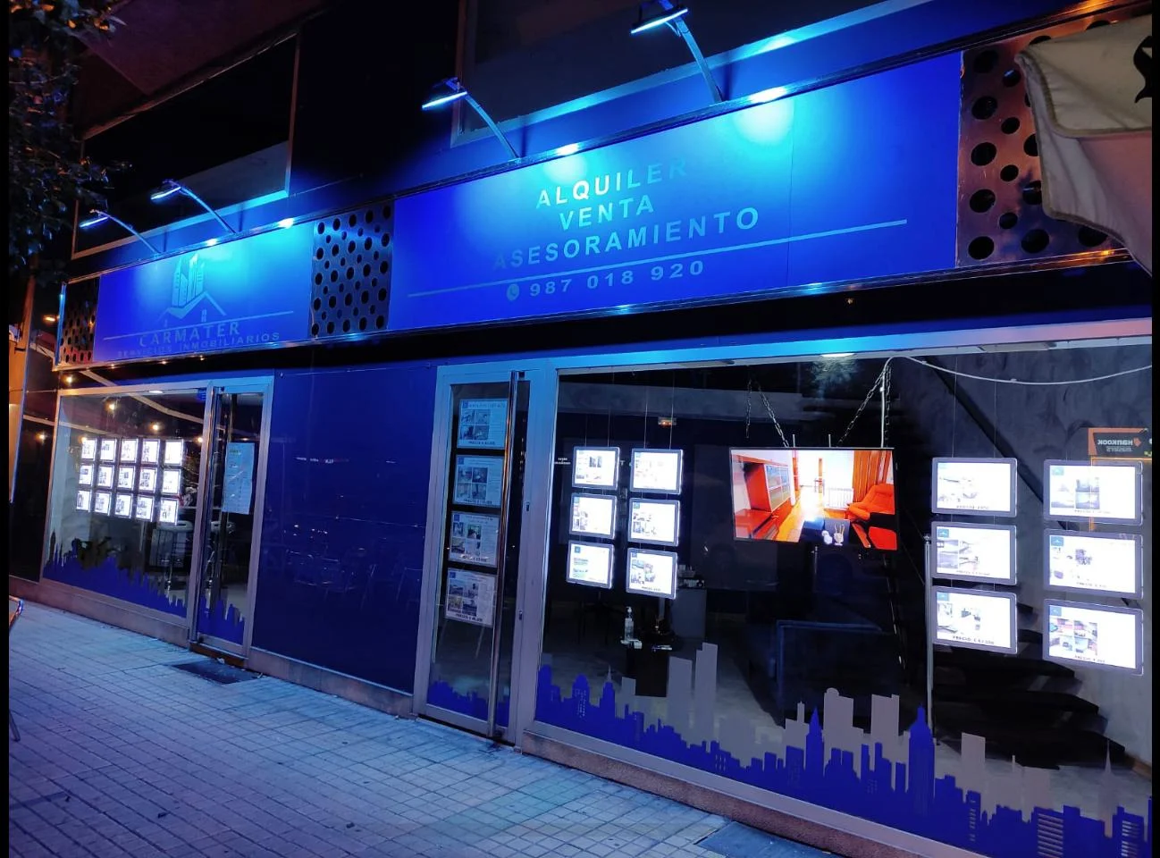 Impacto nocturno de carpetas LED en escaparate inmobiliaria